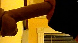 A guy in the hood practices deepthroating a dildo casually