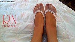 The cute chick in white socks lies on the bed, smiles gracefully, and bends over