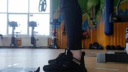 A young 18+ british female shakes her ass in the gym shower while wearing shoes and focusing on feet fetish