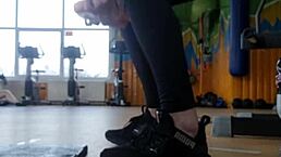 A young 18+ british female shakes her ass in the gym shower while wearing shoes and focusing on feet fetish