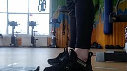 A young 18+ british female shakes her ass in the gym shower while wearing shoes and focusing on feet fetish