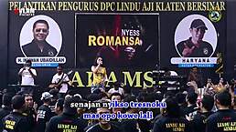 Two pretty indonesian singers perform a wild dance on stage surrounded by men