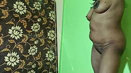 Indian mature woman stands naked to show her hairy pussy lips with big tits and muscular body. She spreads anus and vagina in close-up view.