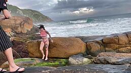 This skinny Brazilian amateur flashes on the beach and sucks big cock without resisting a raw fuck behind rocks.